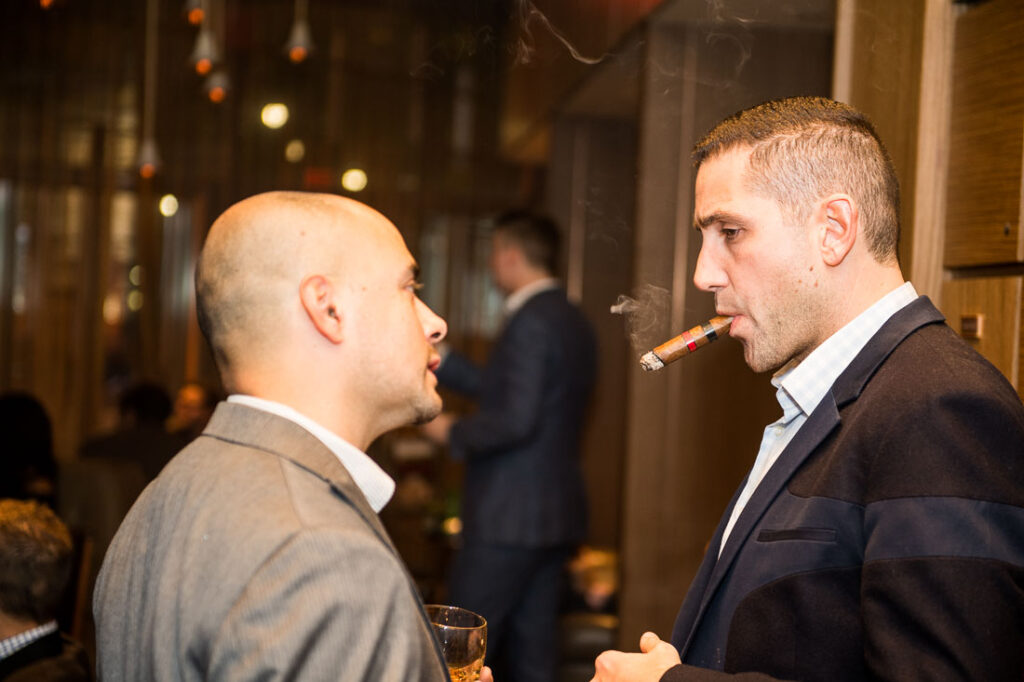 Two guests talking over cigars and whisky at a private tasting