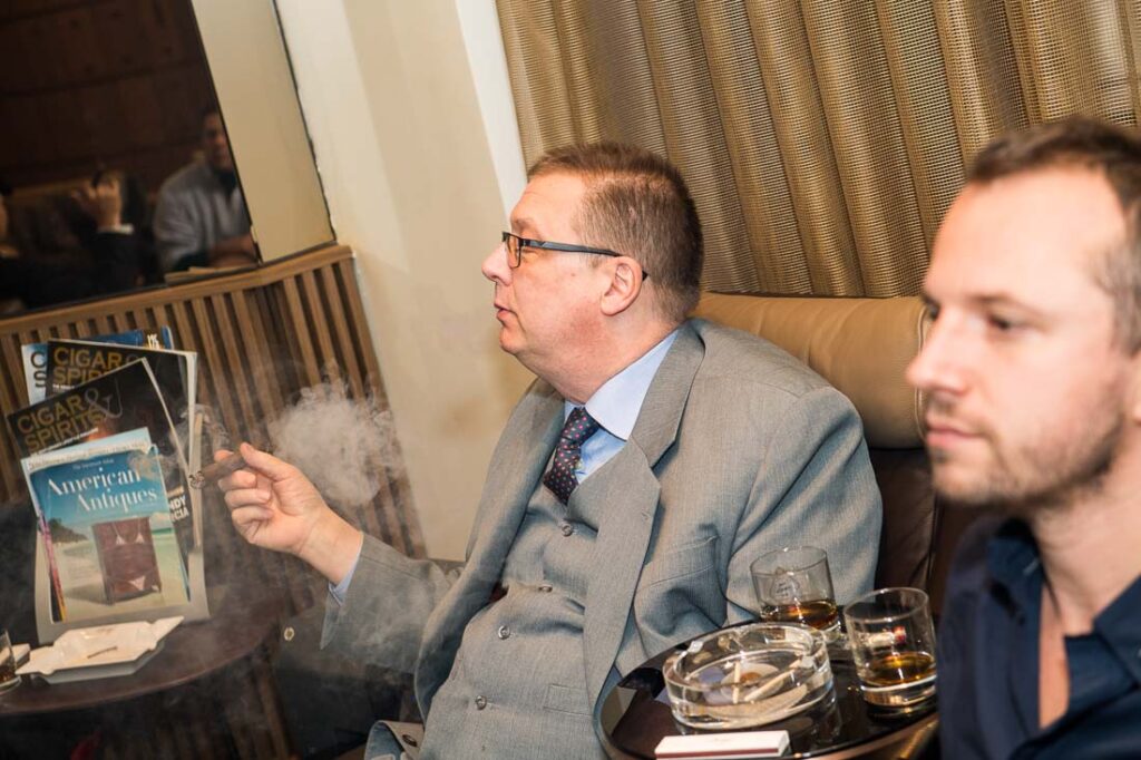 Guest enjoying a cigar and whisky in a private lounge