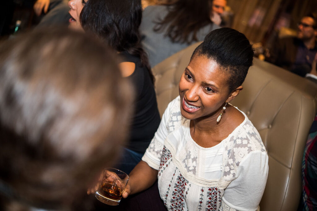 Guest smiling with a glass of whisky at a Fine Tobacco Club event