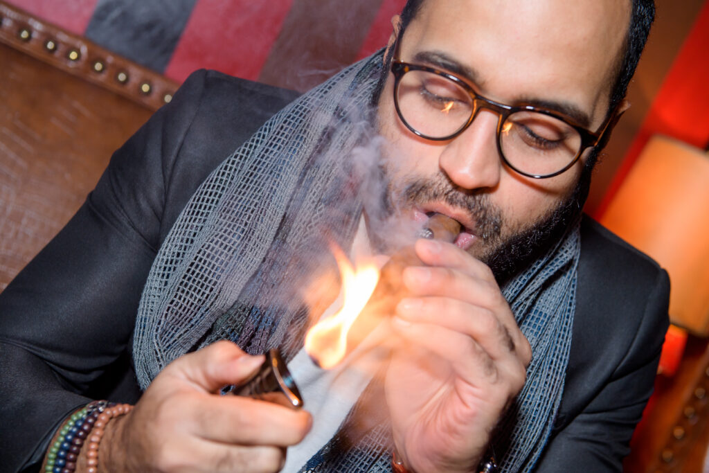 Guest lighting a cigar at a Fine Tobacco Club evening at The Carnegie Club