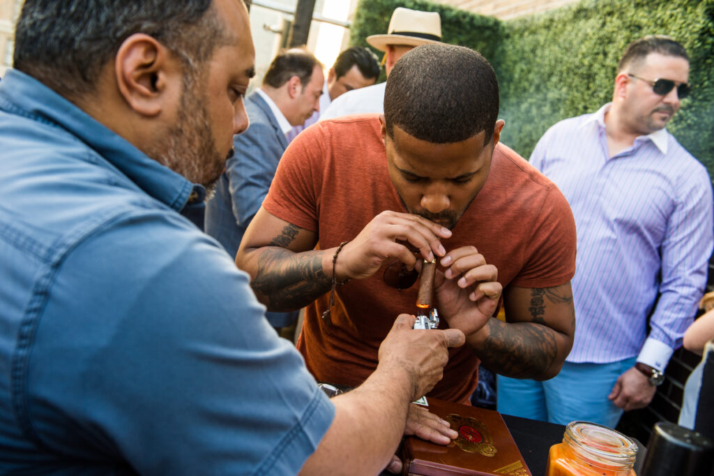 Guest getting a cigar lit on the rooftop at Up On 20