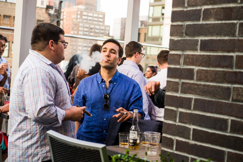 Guest enjoying a cigar on the rooftop at Up On 20, Hyatt Herald Square
