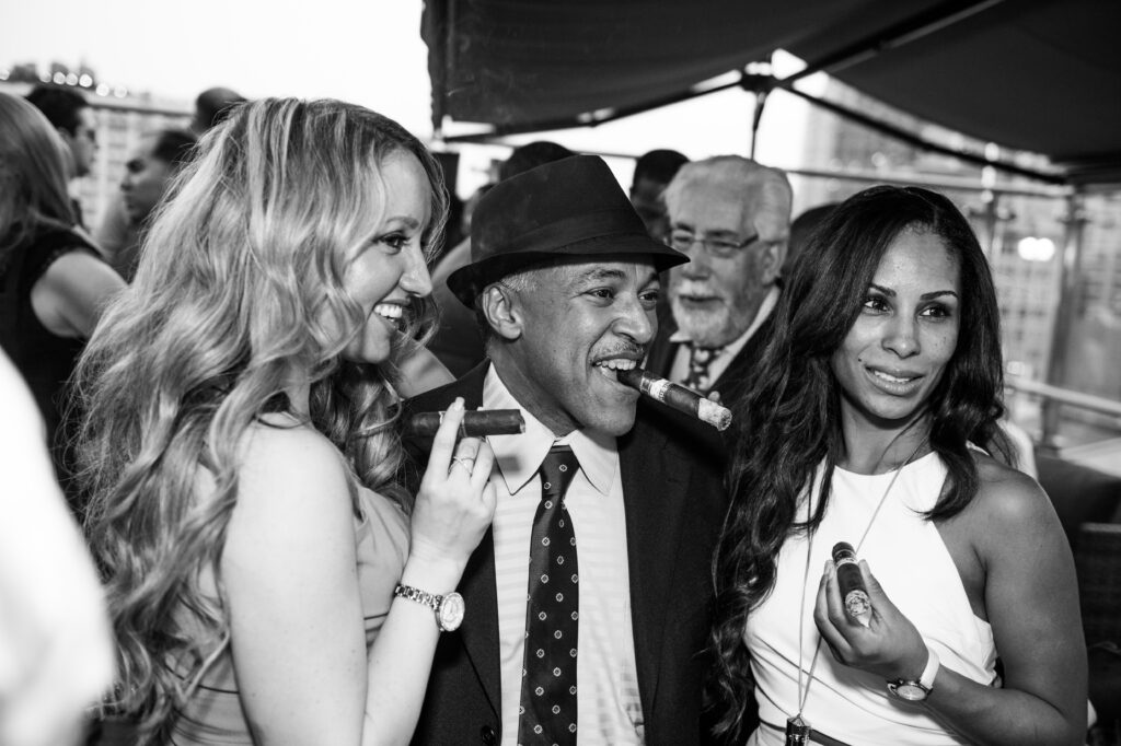 Guests with cigars at a Fine Tobacco Club rooftop smoke