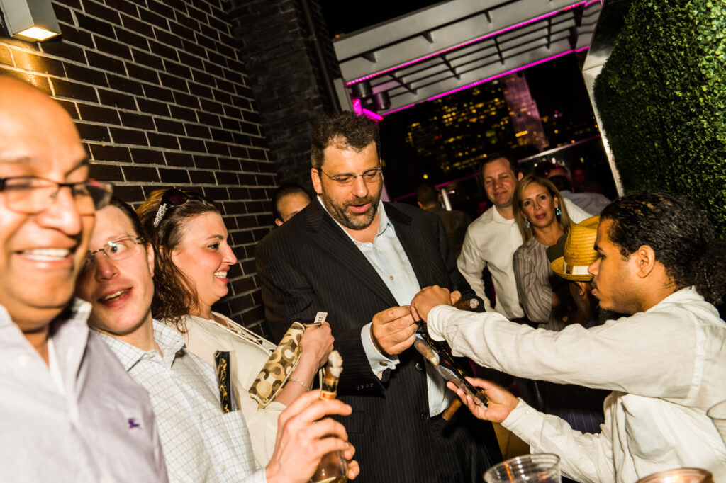 Cigars being handed out at a night rooftop event at Up On 20